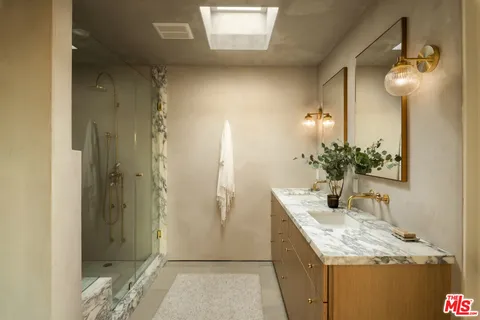 a bathroom with a granite countertop sink and a mirror