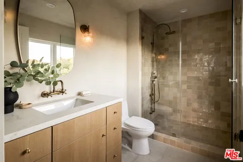 a bathroom with a sink a toilet and shower