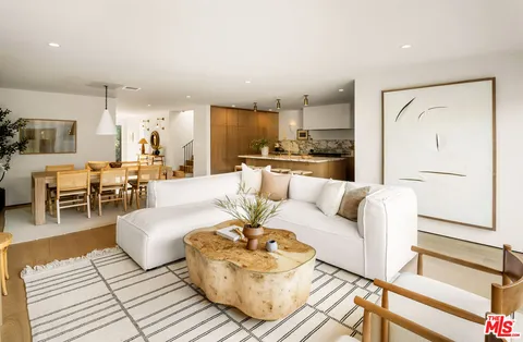 a living room with furniture and a view of kitchen