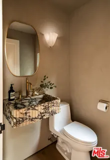 a bathroom with a toilet sink and mirror