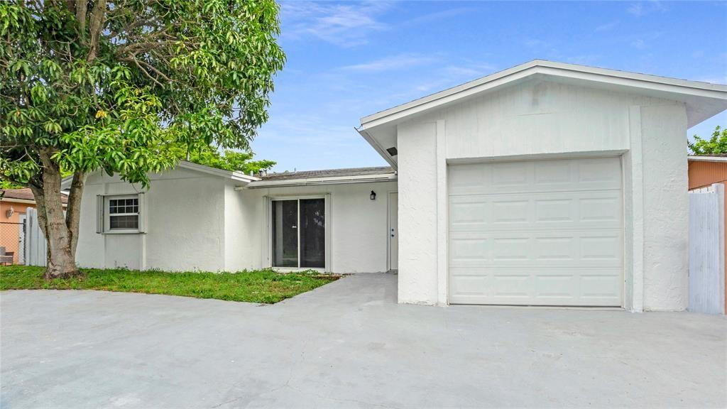 8241 Southwest 3rd Court North Lauderdale, FL 33068 - Photo 2 of 30 a front view of a house with a yard and garage