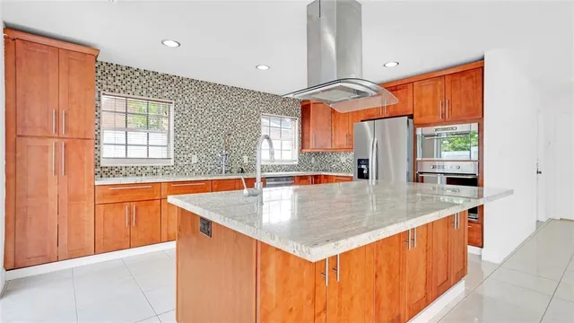a kitchen with stainless steel appliances granite countertop a sink a counter space and a window