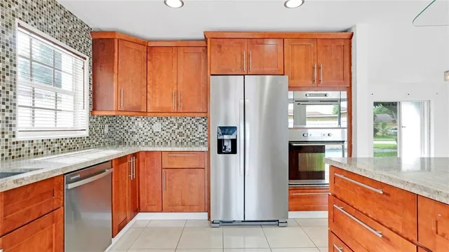 a kitchen with stainless steel appliances granite countertop a refrigerator and a sink
