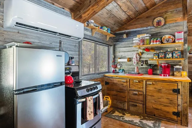 a kitchen with stainless steel appliances granite countertop a refrigerator and a wooden floors