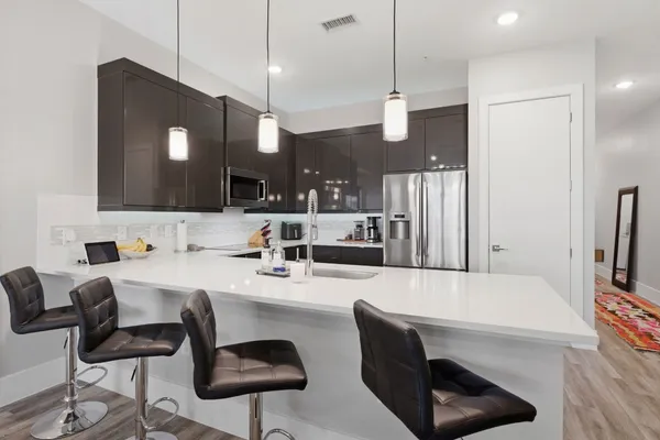 a large kitchen with a table chairs refrigerator and microwave