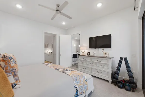 a bedroom with a bed and a flat tv screen on dresser