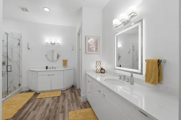 a spacious bathroom with a double vanity sink mirror and shower