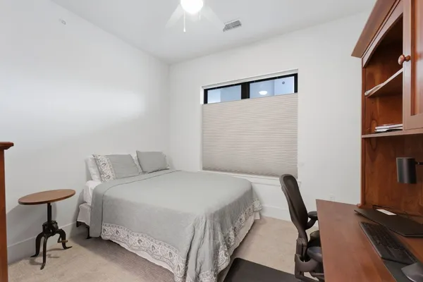 a bedroom with a bed a desk and chair