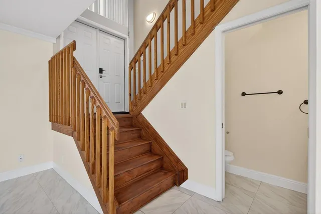 a view of staircase with wooden floor and white walls