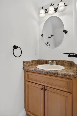 a bathroom with a granite countertop sink and a mirror