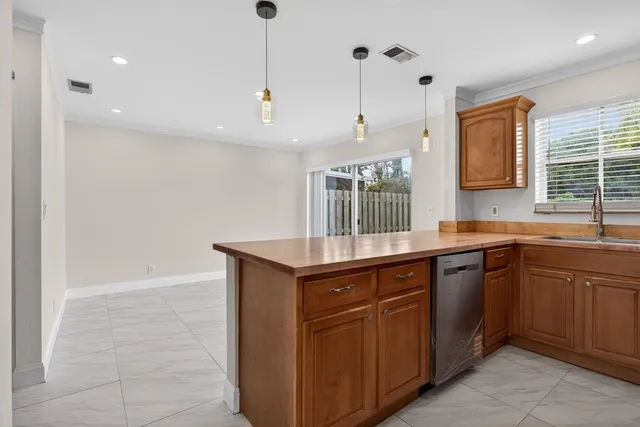 a kitchen with a sink a window and wooden floor