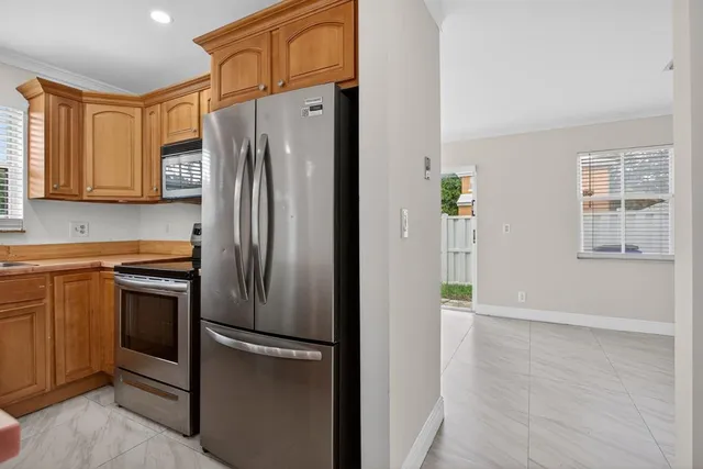 a metallic refrigerator freezer sitting in a kitchen