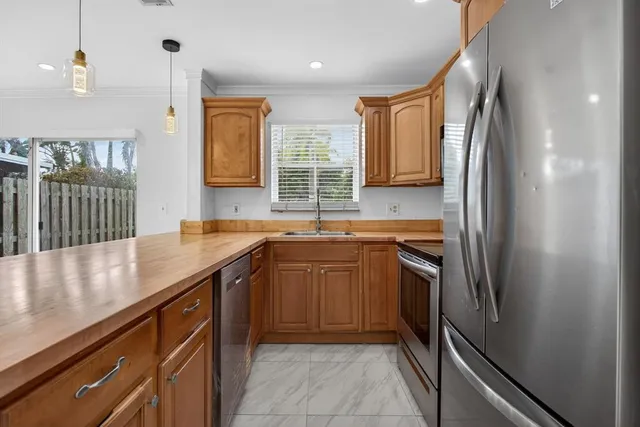 a kitchen with stainless steel appliances granite countertop a sink and a refrigerator