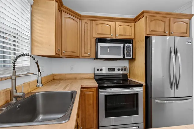 a kitchen with granite countertop a sink stove and refrigerator