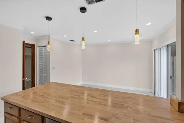 a view of an empty room and kitchen view
