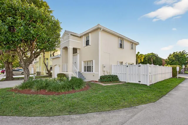 a view of a back yard with flower plants and wooden fence