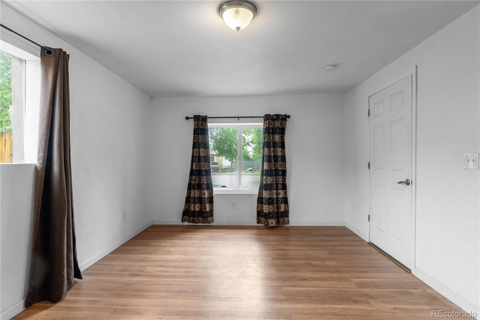 7010 West 44th Avenue Wheat Ridge, CO 80033 - Photo 17 of 31 an empty room with wooden floor and windows