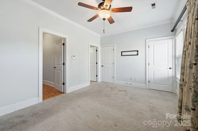 an empty room with closet and a chandelier fan