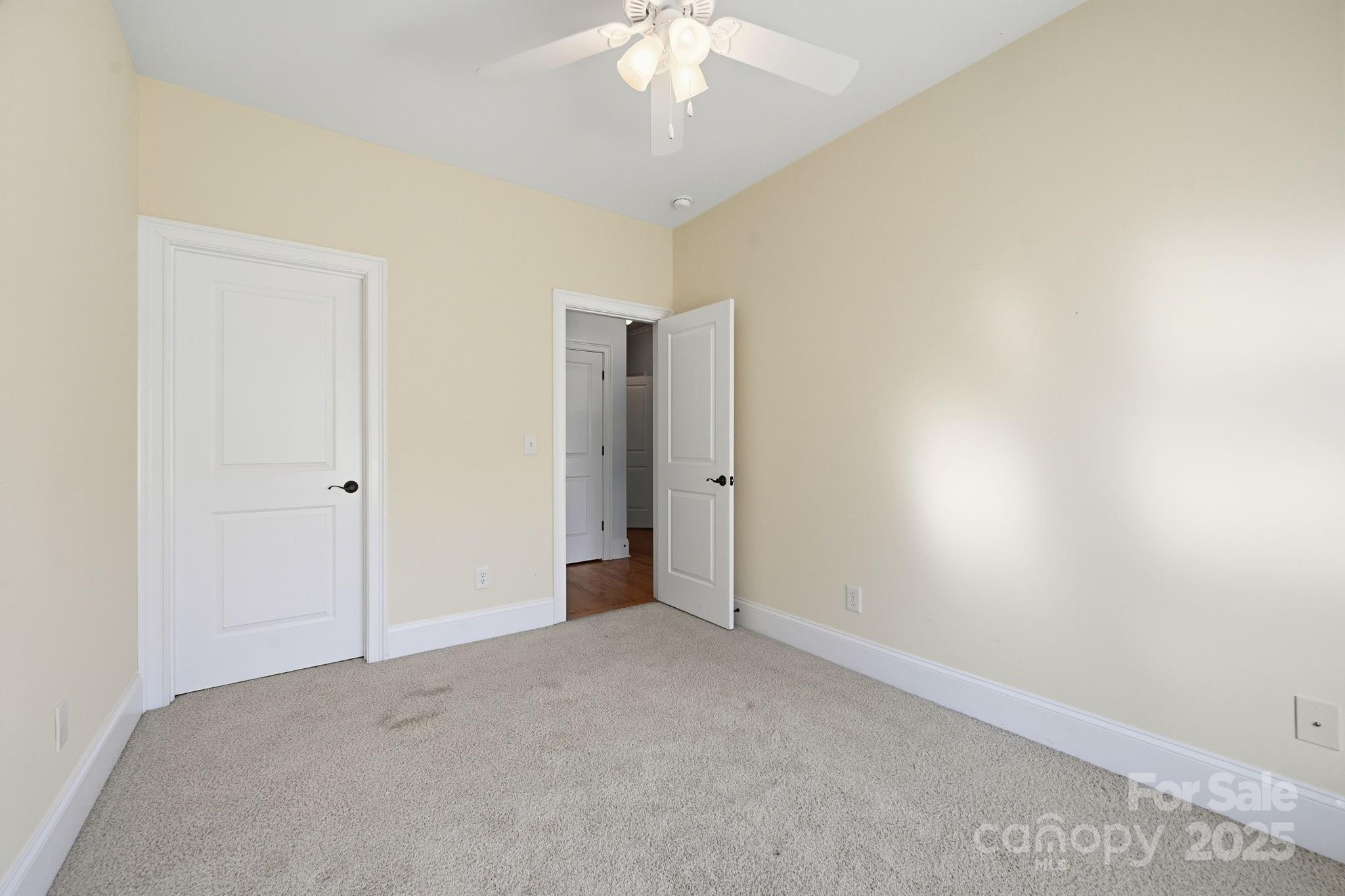 329 Spring Street Davidson, NC 28036 - Photo 17 of 31 an empty room with a chandelier fan and closet