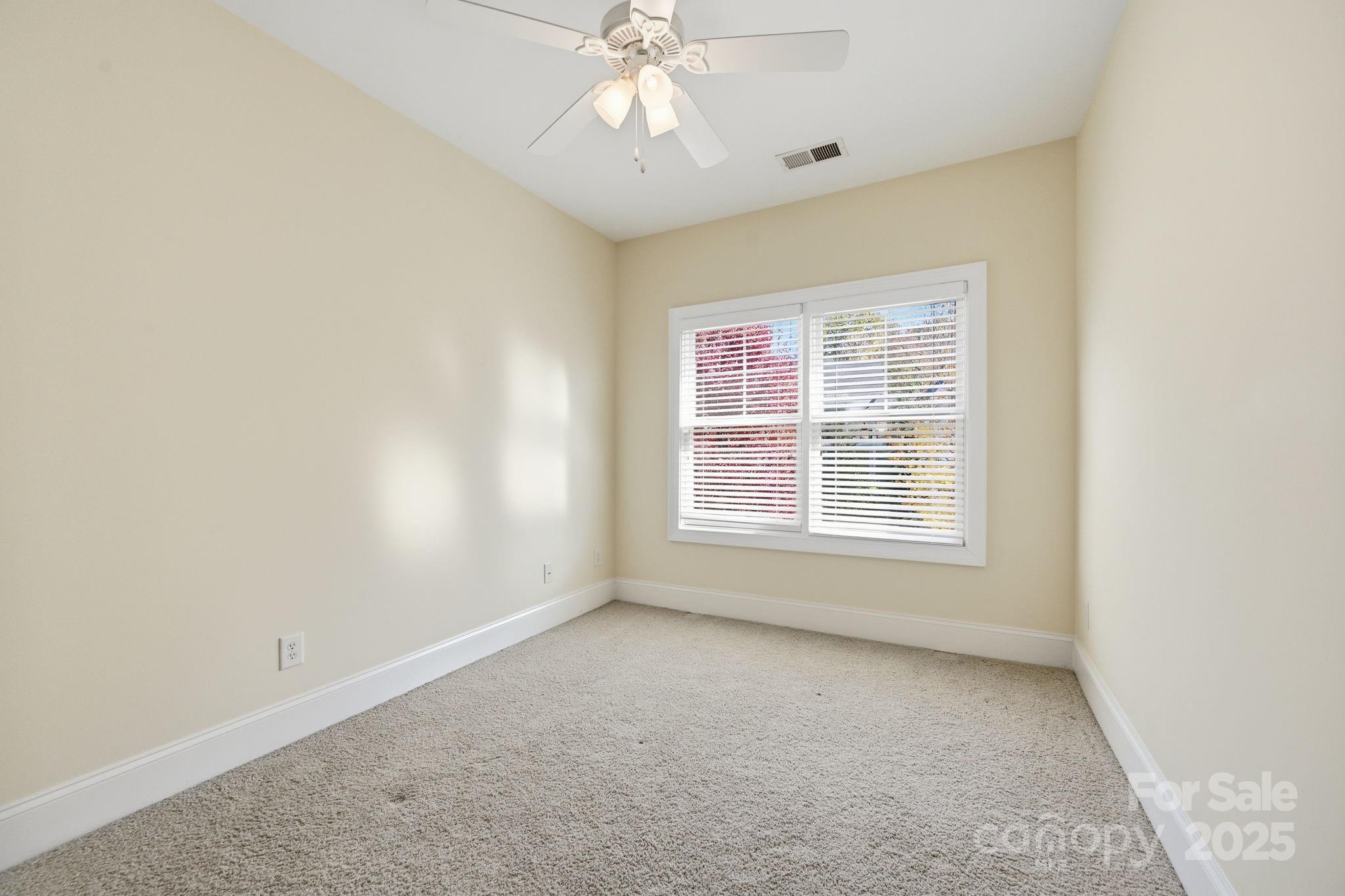 329 Spring Street Davidson, NC 28036 - Photo 19 of 31 an empty room with a chandelier fan and windows