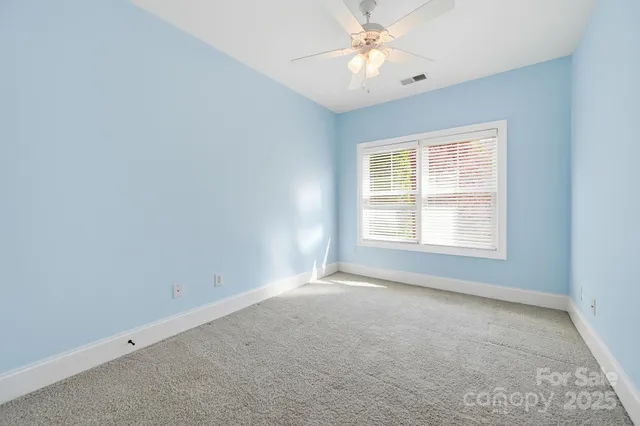 an empty room with a chandelier fan