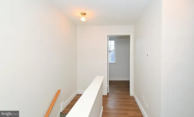 an empty room with wooden floor and a window