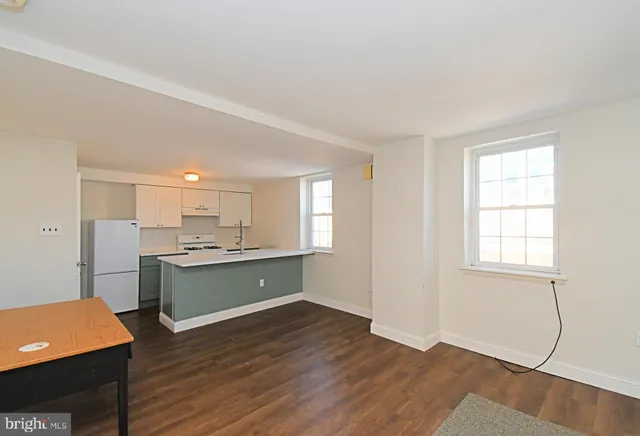 a kitchen with stainless steel appliances granite countertop a sink cabinets and wooden floor
