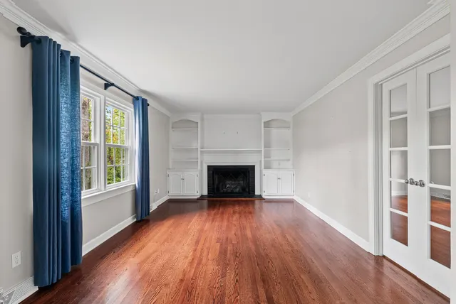 wooden floor fireplace and windows in an empty room