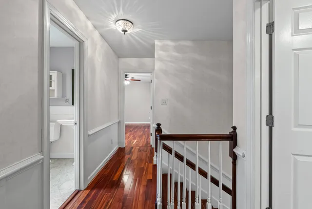 a view of a hallway with wooden floor and staircase