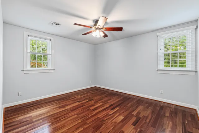 a view of empty room with wooden floor