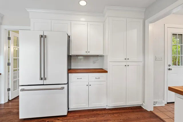 a view of cabinets a wooden floor and a window in a kitchen
