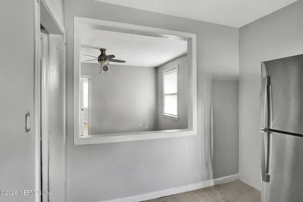 a view of empty room with wooden floor and fan