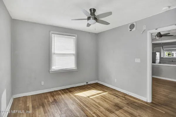 a view of a livingroom with wooden floor and a ceiling fan