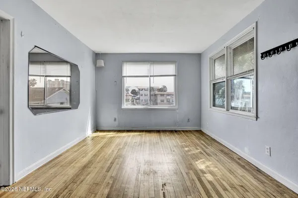 a view of empty room with wooden floor and cabinet