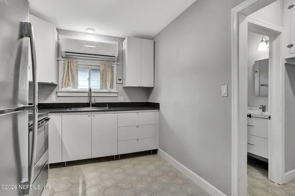 a kitchen with granite countertop white cabinets and white appliances