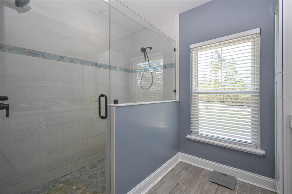 7890 Southwest 129th Avenue Cedar Key, FL 32625 - Photo 25 of 45 a bathroom with a window a shower and vanity