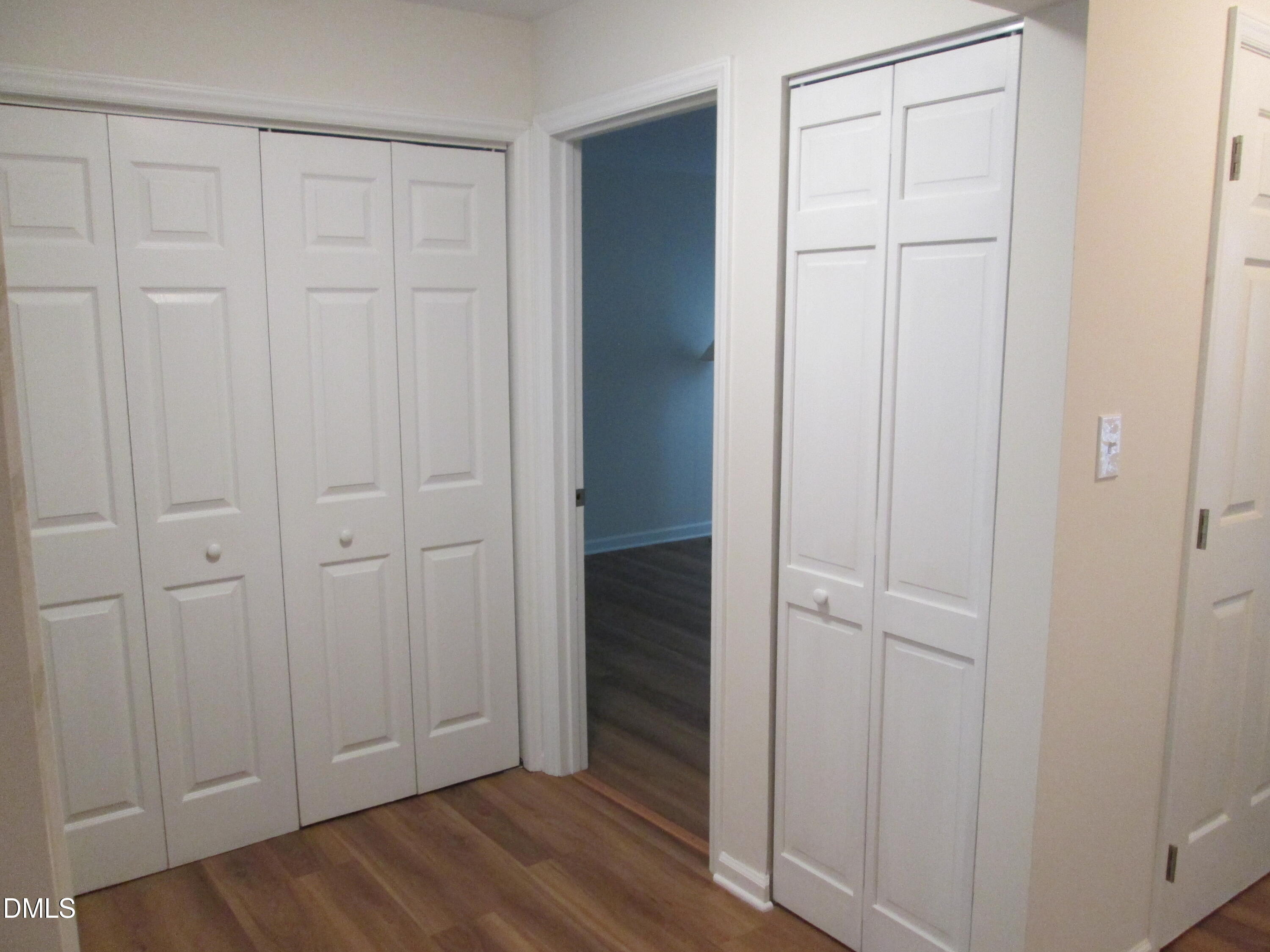 4651 Timbermill Court, Unit 103 Raleigh, NC 27612 - Photo 20 of 40 Wood-finish flooring with white paneled bifold doors and light neutral wall paint