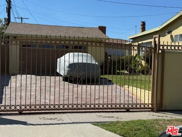 a view of a brick house with a wooden fence