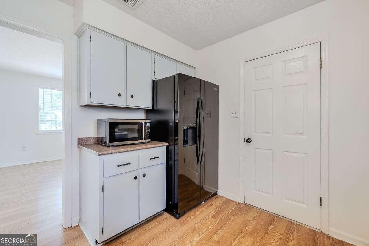 412 Rothwell Street Pooler, GA 31322 - Photo 11 of 32 a kitchen with stainless steel appliances granite countertop a refrigerator and white cabinets