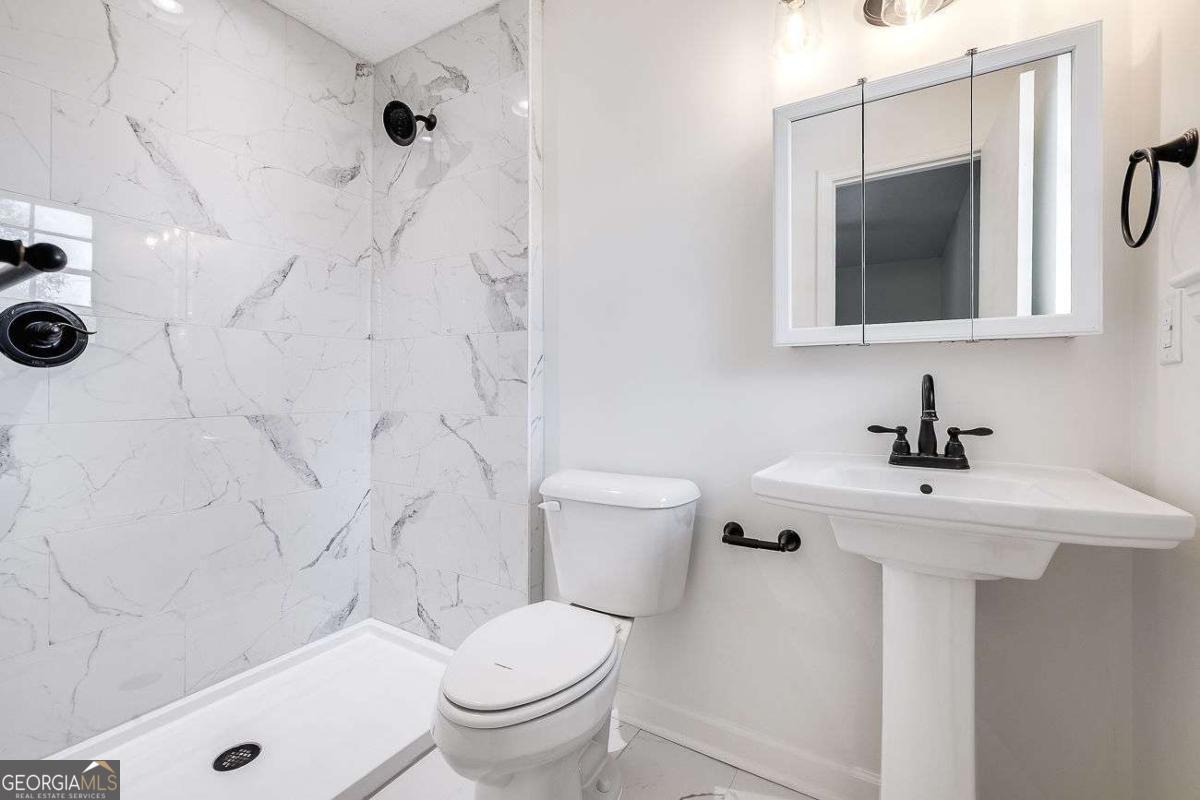 412 Rothwell Street Pooler, GA 31322 - Photo 21 of 32 a bathroom with a sink toilet a mirror and shower