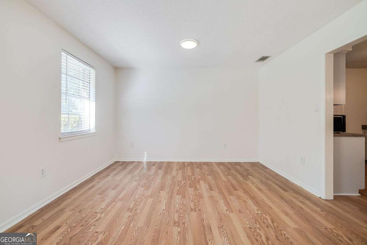 412 Rothwell Street Pooler, GA 31322 - Photo 9 of 32 an empty room with wooden floor and windows