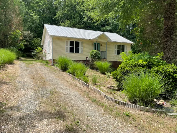 a front view of house with a yard and green space