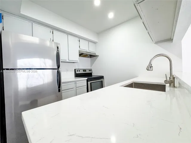 a kitchen with a refrigerator and a sink