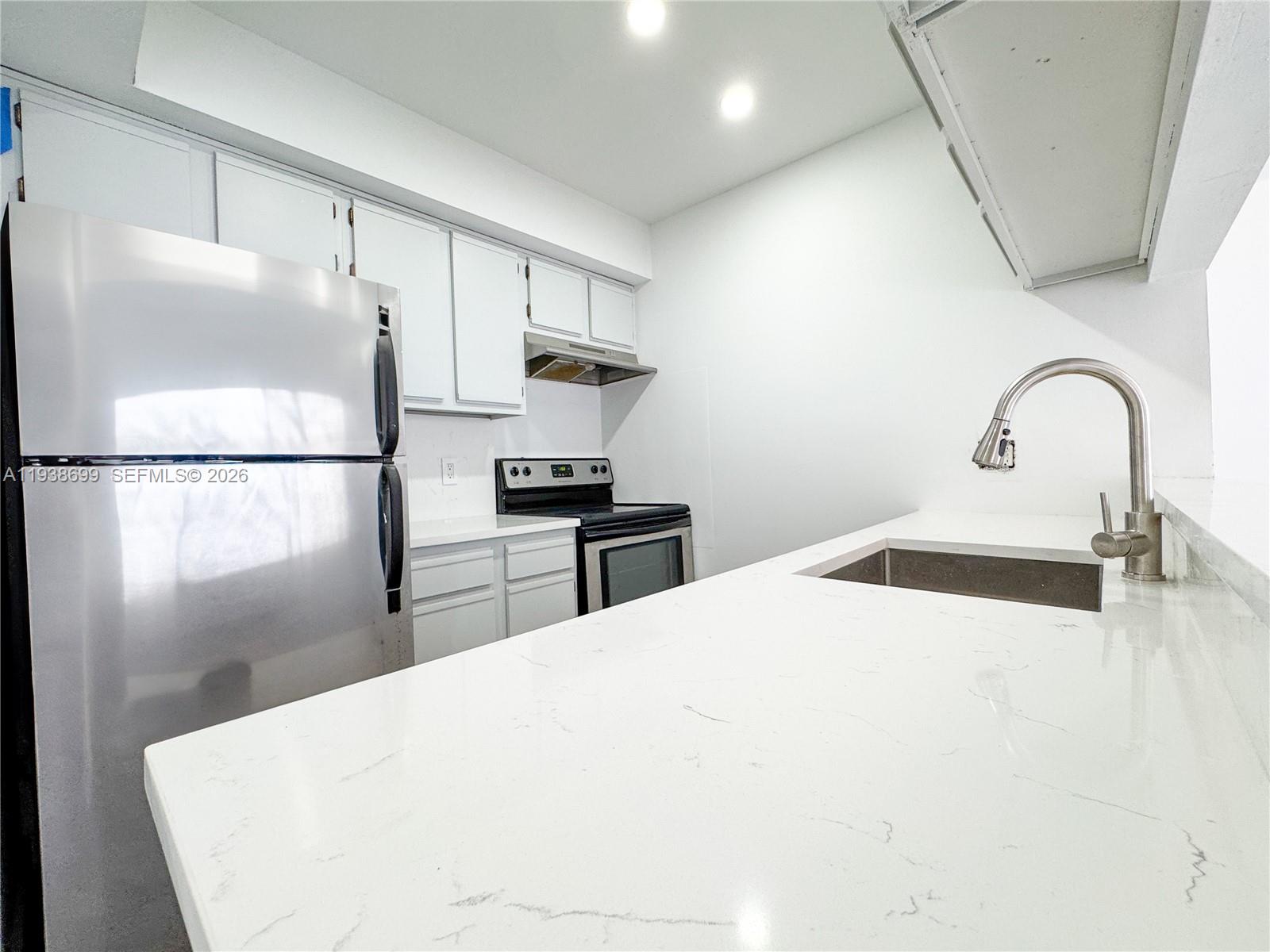 5672 Rock Island Road, Unit 271 Tamarac, FL 33319 - Photo 2 of 11 a kitchen with a refrigerator and a sink
