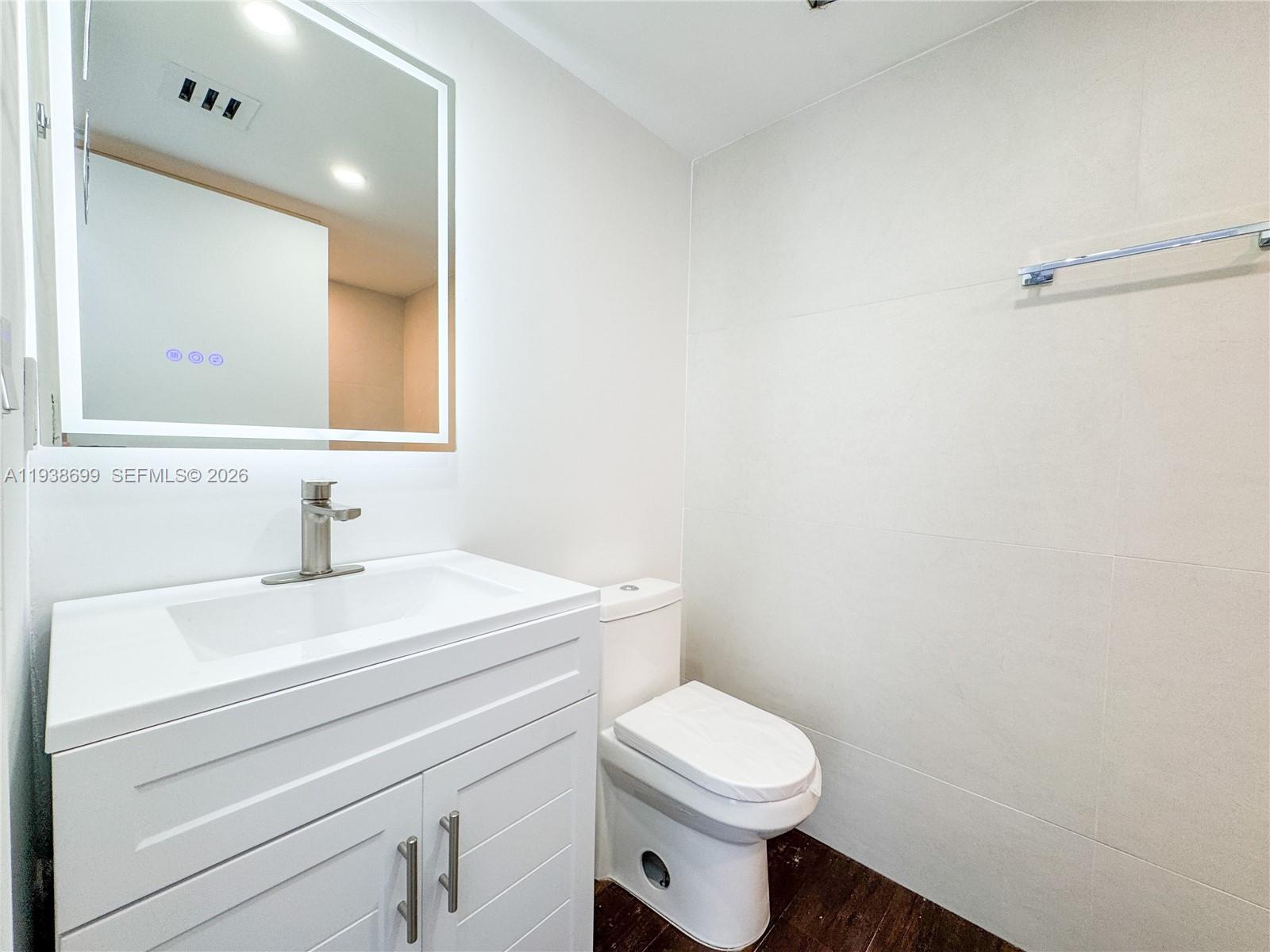 5672 Rock Island Road, Unit 271 Tamarac, FL 33319 - Photo 6 of 11 a bathroom with a toilet a sink and mirror