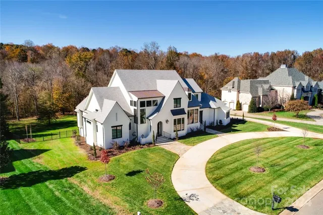 an aerial view of residential houses with yard and trees
