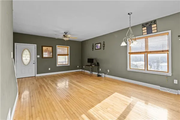 a room with chandelier and wooden floor