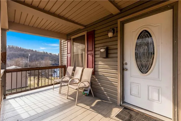 a view of a balcony with furniture and wooden floor