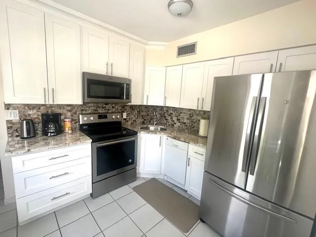 a kitchen with a refrigerator stove and microwave