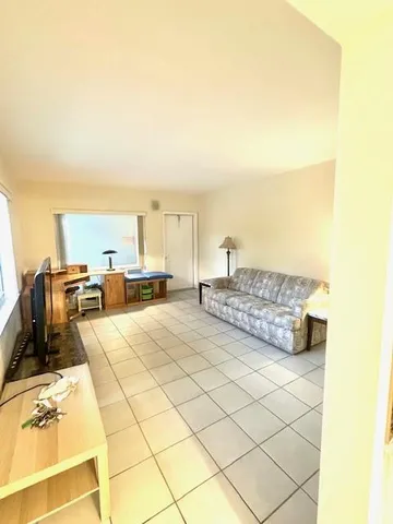 a living room with couches and kitchen view